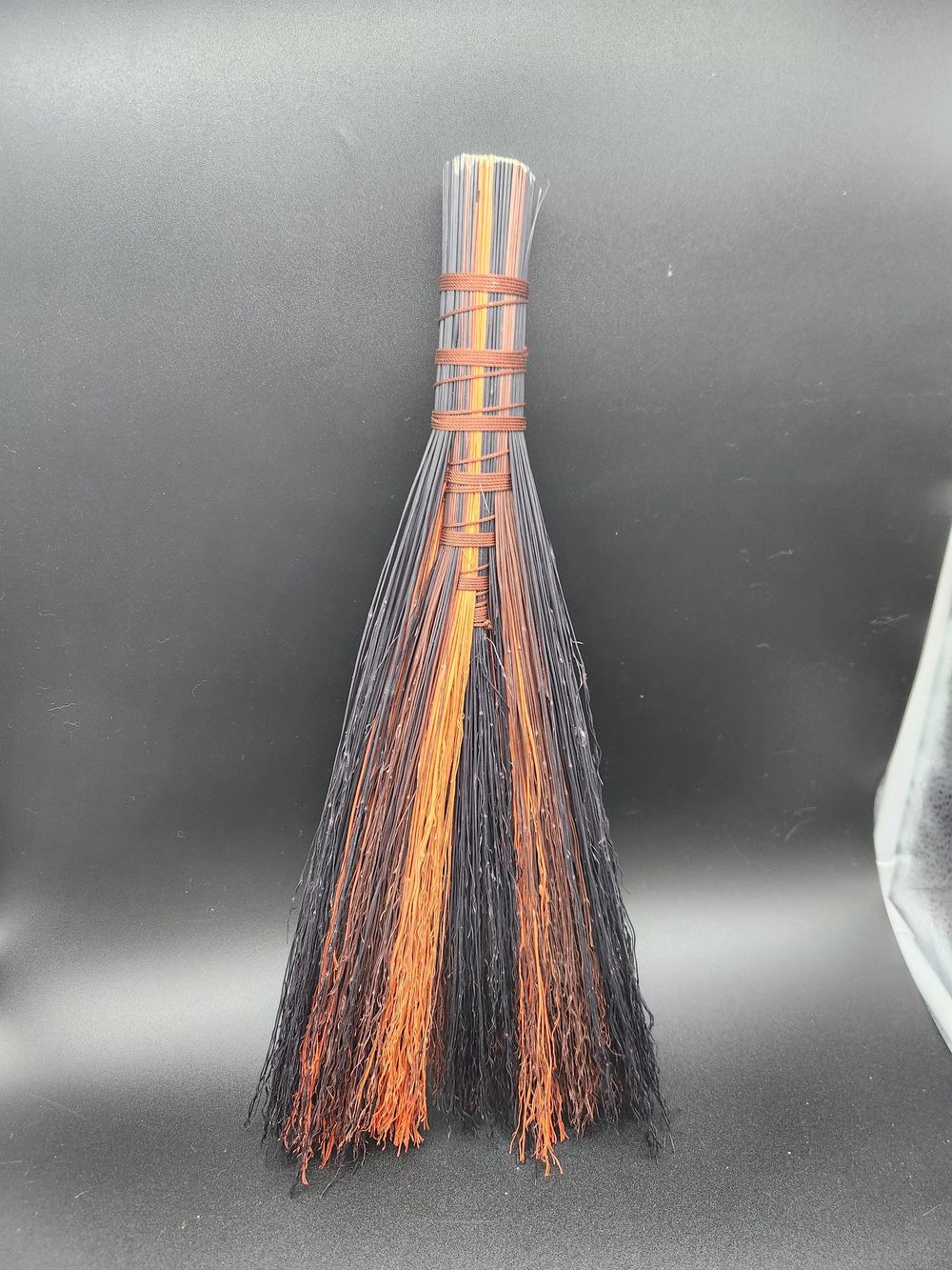 Brown, orange, and black handmade broom